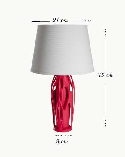 A table lamp with a white pleated drum shade and a glossy red sculptural base, shown with dimension labels indicating 21 cm width, 35 cm height, and 9 cm base width on a light background.