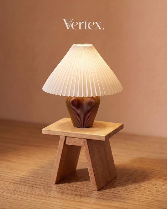 Small table lamp with pleated shade on a  stand against a beige background, featuring the brand 'Vertex'.