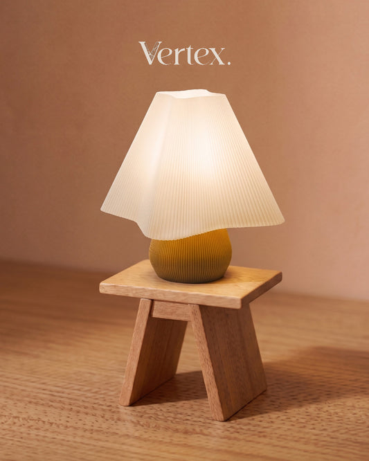Small table lamp with a ribbed white shade and green base on a wooden stand against a beige background, branded 'Vertex'.