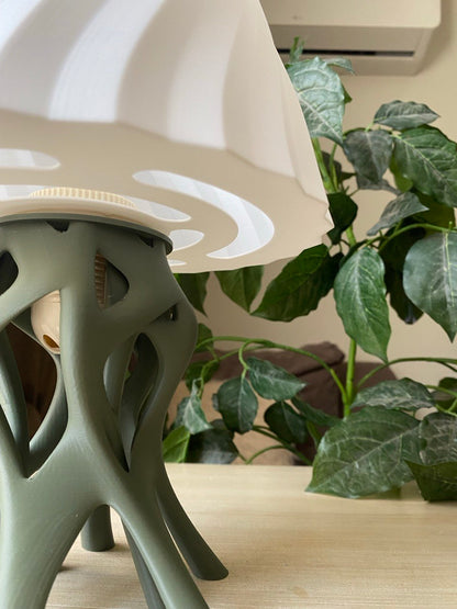 Table lamp with unique base design on a wooden stand against a warm brown background, featuring the brand 'Vertex'.