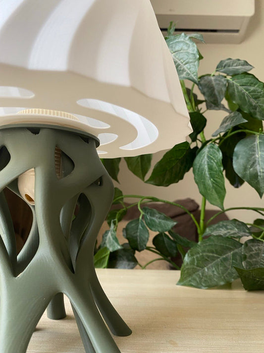 Table lamp with unique base design on a wooden stand against a warm brown background, featuring the brand 'Vertex'.