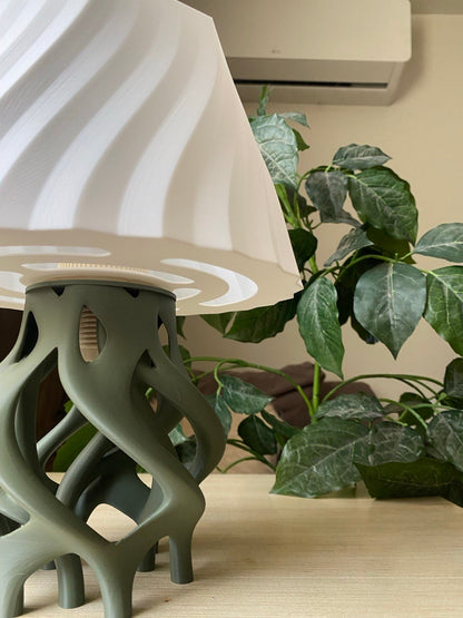 Decorative lamp with a unique base on a wooden stand against a brown background, featuring the brand 'Vertex'.