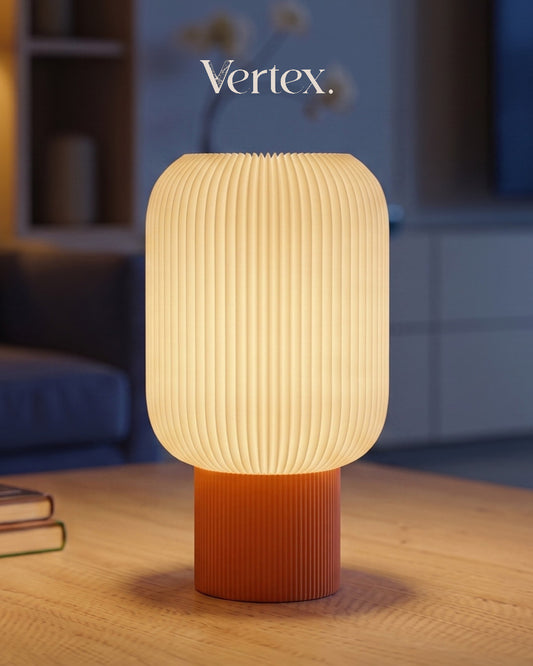 Table lamp with ribbed design on a wooden surface, blurred background with 'Vertex.' branding.