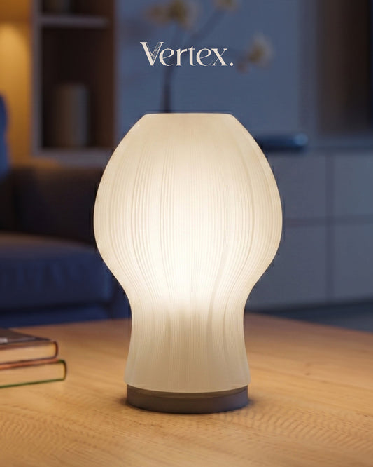 Decorative table lamp with ribbed design on a wooden surface, featuring the brand 'Vertex'.