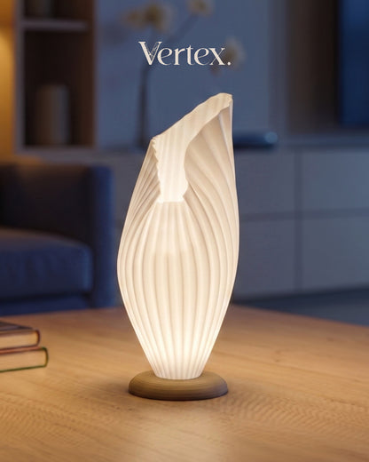 Decorative table lamp with ribbed design on a wooden surface, blurred background with 'Vertex' branding.