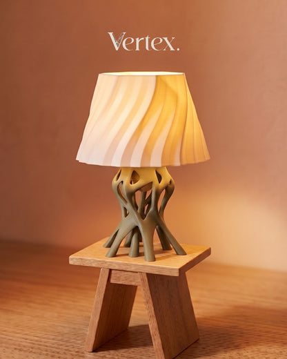 Table lamp with unique base design on a wooden stand against a warm brown background, featuring the brand 'Vertex'.