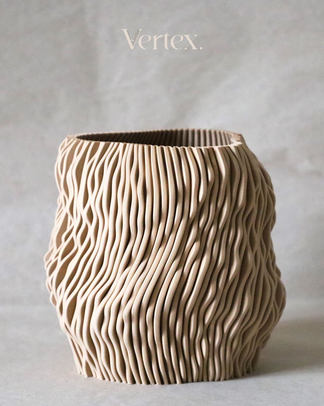 Textured ceramic vase with 'Vertex' branding on a neutral background